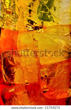 Ice cubes swimming in orange drink.