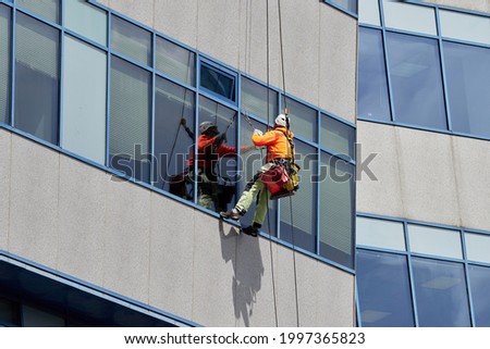 Similar – Image, Stock Photo Unrecognizable alpinist cleaning windows of building