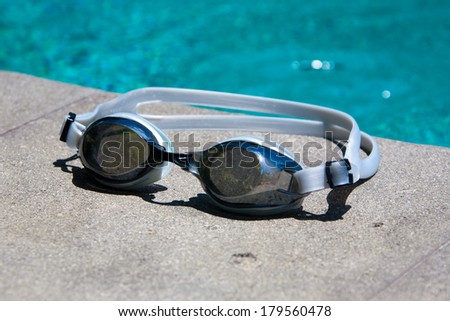 Swimming sport goggles on the poolside