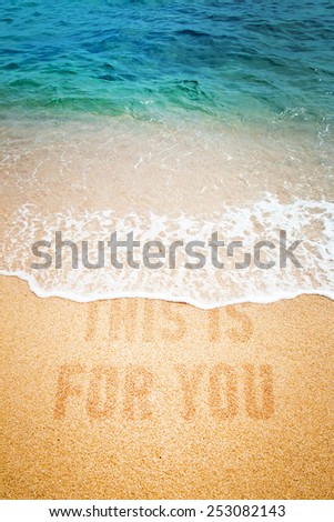 Surf wave on a inscription This Is For You on a sea beach