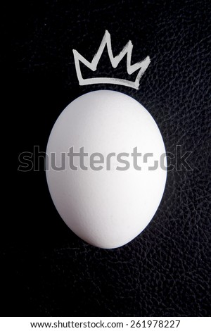 White egg with a crown on a black background