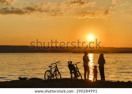 Cyclists at the river at sunset