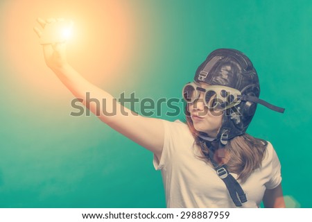 Girl in pilot helmet meking a selfie by smartphone