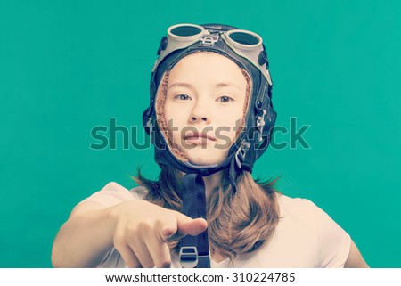 Girl in a flying helmet points finger