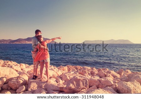 Man and woman greets the sun on the beach