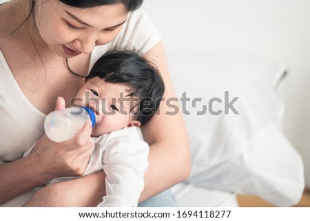 Similar – Image, Stock Photo Newborn drinking milk from a baby bottle, sitting on mom legs outdoors