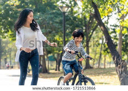 Similar – Foto Bild Mutter und Sohn reiten entlang des Parkwegs