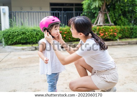 Similar – Image, Stock Photo Mother putting bicycle helmet on her son