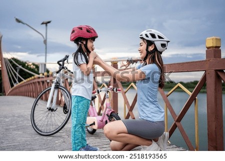 Similar – Image, Stock Photo Mother putting bicycle helmet on her son