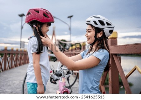 Similar – Image, Stock Photo Mother putting bicycle helmet on her son