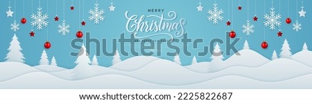 Merry Christmas and Happy New Year horizontal banner in paper cut style. Winter landscape with christmas balls and snowflake, stars hanging on ribbon. Merry Christmas text calligraphy lettering design