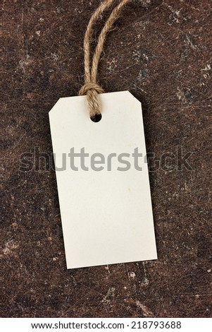 price tag from recycled paper on twine cord on brown background