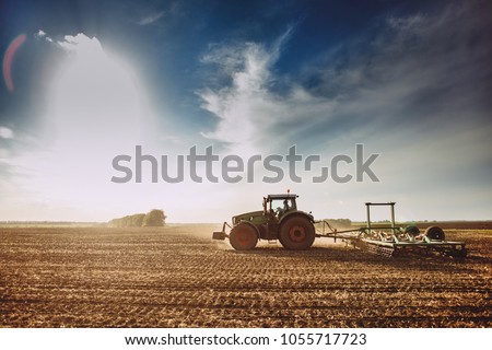 Image, Stock Photo Potato plantation and tractor farmer cultivating rows. Agroindustry and agribusiness. Cultivation of a young potato field. Loosening of the soil between the rows of bushes. Blurry