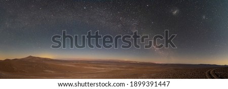 An amazing panoramic view of the Milky Way above Atacama Desert vast sand fields. An awe night sky view with our galaxy arm creating an arch in between the stars. An idyllic and motivational scenery.