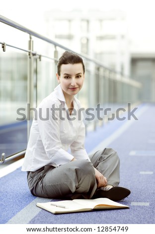 Businesswoman is sitting on the floor with a calendar beside her