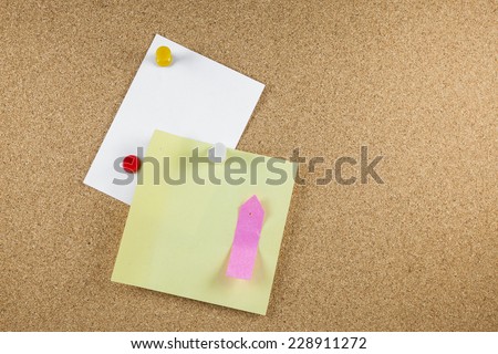 Blank white note papers is pinned to a cork board.