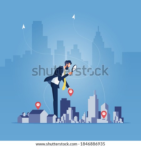 Businessman holding magnifying glass and Building, building selection