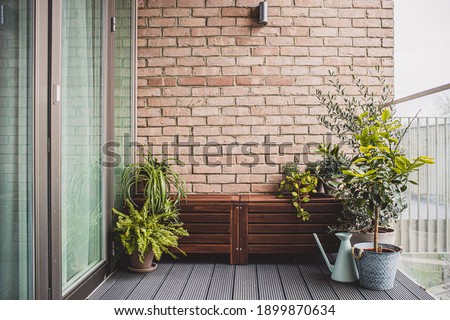 Morden residential balcony garden with bricks wall, wooden bench and plants. Imagine de stoc © 