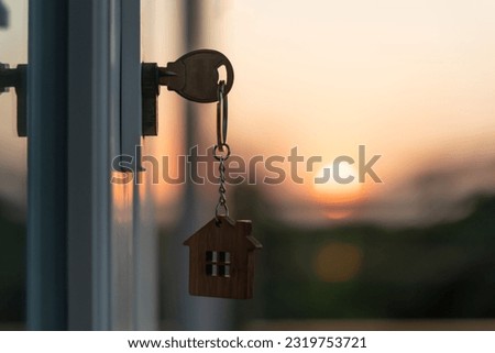 Landlord key for unlocking house is plugged into the door. Second hand house for rent and sale. keychain is blowing in the wind. mortgage for new home, buy, sell, renovate, investment, owner, estate Foto stock © 