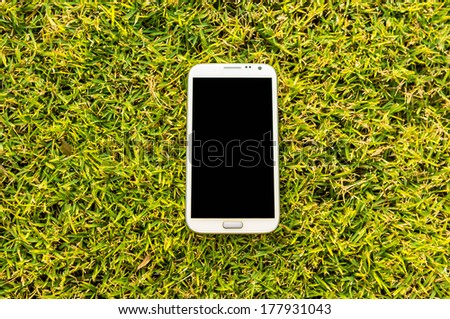 empty touch screen mobile phone on the grass field