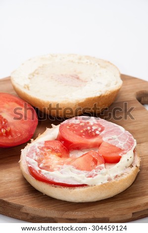 Sandwich with pasta and fresh tomatoes on the wooden board.