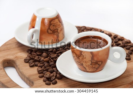 A cup of coffee with raw coffee beans.