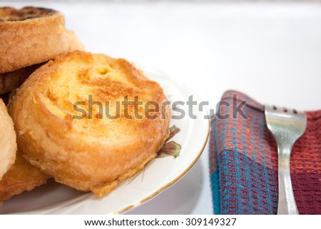 French toast on the plate and metal fork in shallow depth of field.