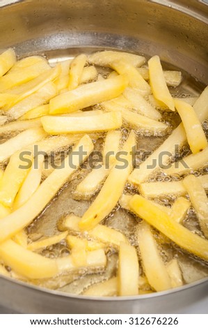 French fries in the pan in hot oil.