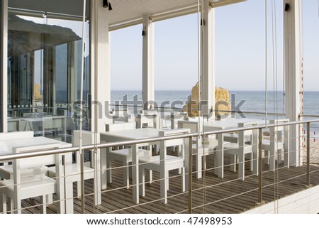 tables and chairs in stylish restaurant on an ocean coast, with sea view - Algarve, south of portugal