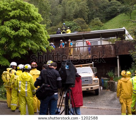 Rescue workers trying to save man buried in mud slide behind house, Mill Valley, California