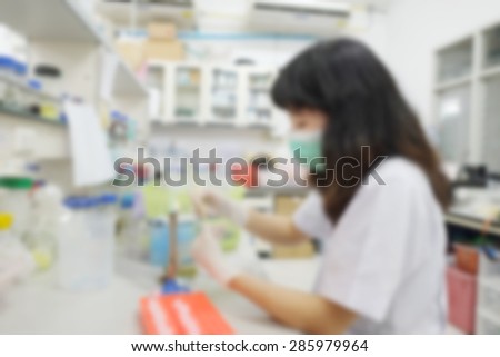 blurred image of research scientist putting test tube into real-time pcr machine