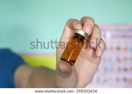 Close up of a small glass bottle (pill/sirup bottle) in hand