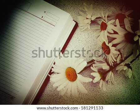 Daisy flowers and phone book. Design in retro style with shallow canvas texture overlay. Filtered image.