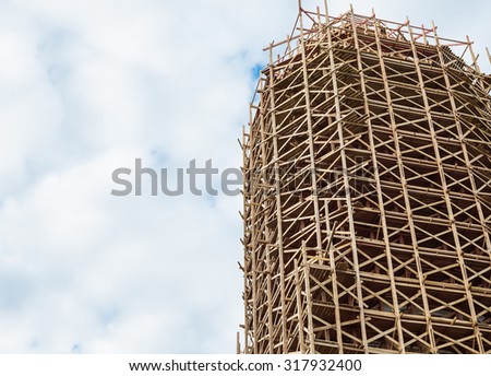 Reconstruction of the old building. Wooden scaffolding on an old building exterior.