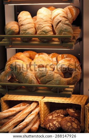 Various kinds of fresh baked bread on the shelves at the bakery. Shallow focus.