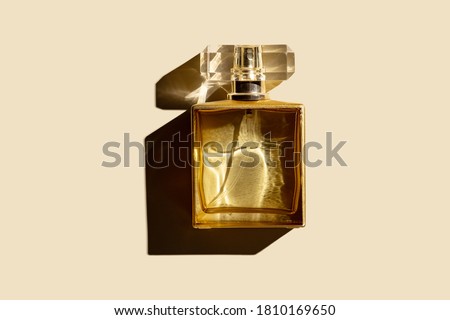 bottle of woman perfume on a pastel beige background, top view, flat lay. Mockup of gold fragrance perfume bottle mockup on pastel beige empty background.