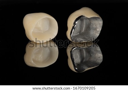 The base intaglio surface comparison between full zirconia crown and a metal ceramic/porcelain jacket dental crown with a dark background and reflection Stockfoto © 