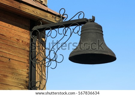 Metal bell on a wooden wall