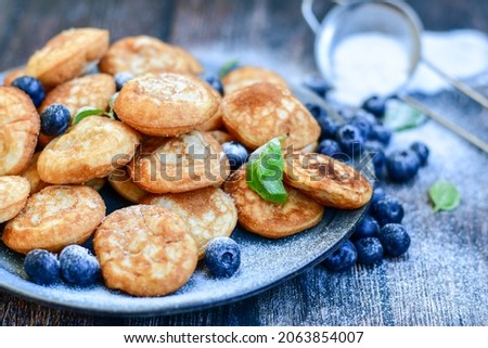 Similar – Image, Stock Photo Mini pancakes with butter and blueberries lie in a plate on a wooden table. Brunch, dessert for children, trending food. Space for text