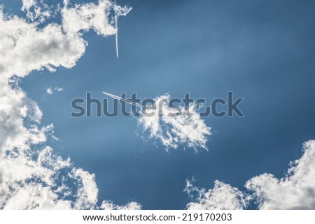 beautiful blue sky with storm clouds sun rays and jet passengers lines
