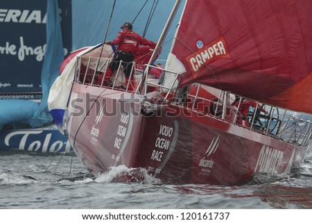 GALWAY, IRELAND - JULY 7: Unidentified crewman on bow of Camper Emirates Team New Zealand brings in spinnaker during In-port race of 2011-2012 Volvo Ocean Race in Galway, Ireland on July 7, 2012.