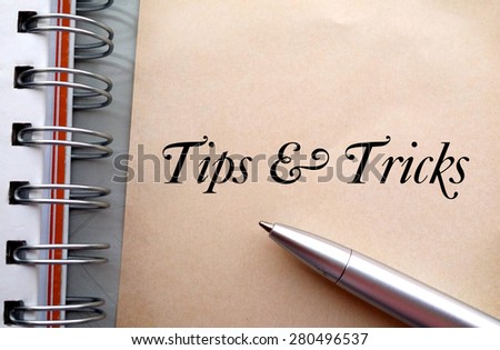 Tips and tricks text write on paper as background with pen and book