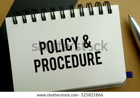 Policy and procedure memo written on a notebook with pen
