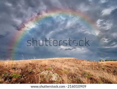 dramatic storm cloud and rainbow over the field, natural background
