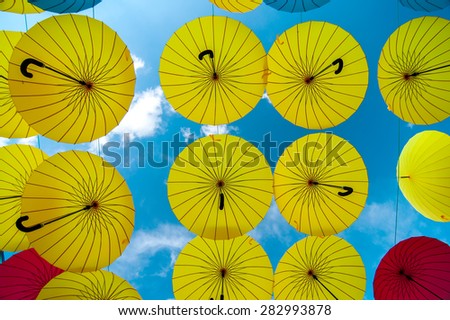 colorful yellow, red and blue umbrellas under the beautiful cloudy sky