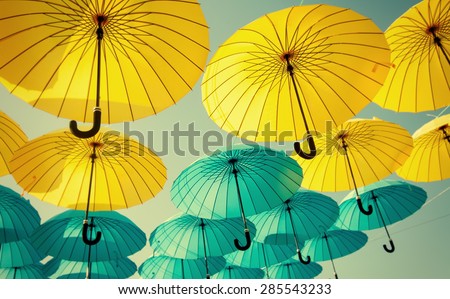 yellow and blue umbrellas under the beautiful cloudy sky. color