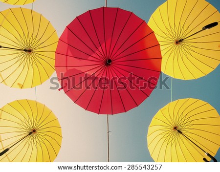 colorful yellow and red umbrellas under the beautiful cloudy sky