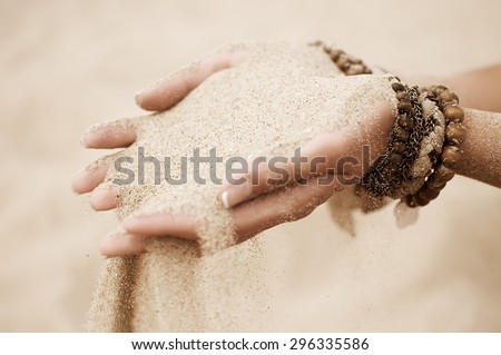 young woman hands holding sand on the beach. natural vintage summer background