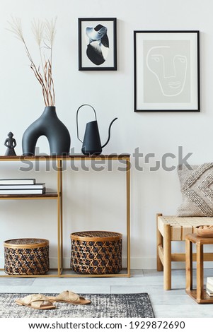 Modern composition in stylish living room interior with design armchair, mock up poster frames, carpet, decoration, dried flowers, rattan basket and elegant accessories in home decor. 
