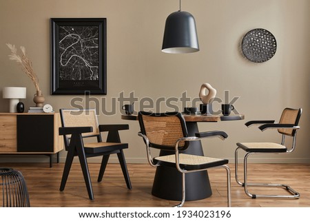 Modern composition of dining room interior with design wooden table, stylish chairs, decoration, teapot, cups, vessel, commode, black mock up poster map and elegant accessories in home decor. Template